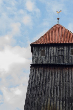 Wooden tower with red tiled roof and weather vane
