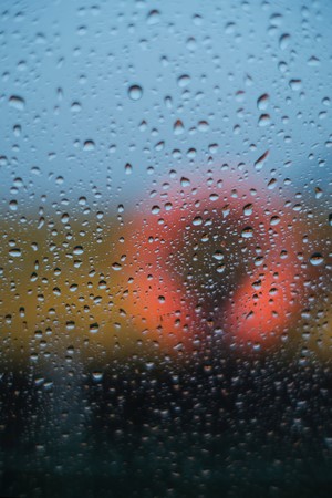 Raindrops on a window with blurred orange and yellow background