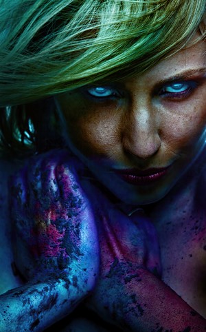 Woman with blue eyes and paint splatter on hands