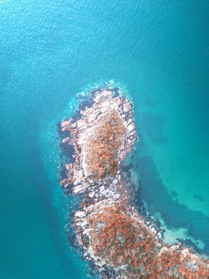 Aerial view of rocky island in turquoise water