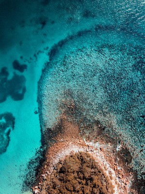 Aerial view of a tropical island coastline with coral reefs