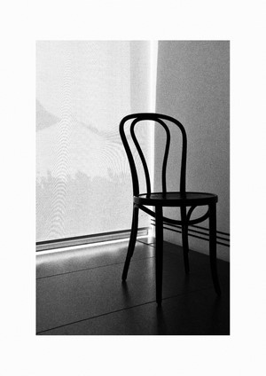 Monochrome bentwood chair by a window