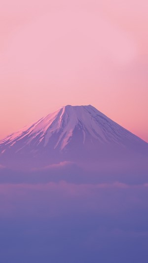 Snow-covered mountain peak above clouds at sunset