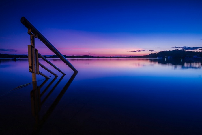 Sunset over a calm lake with a submerged structure