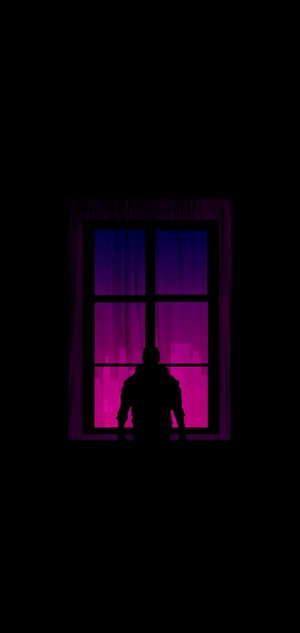 Silhouette of a person looking out a window at a city skyline