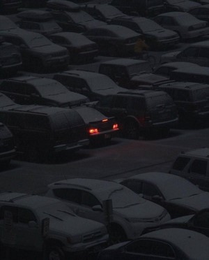 Cars in a snowy parking lot at night