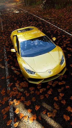 Yellow Lamborghini Huracán LP610-4 on a road with autumn leaves
