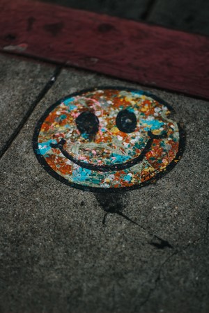 Graffiti smiley face on concrete sidewalk