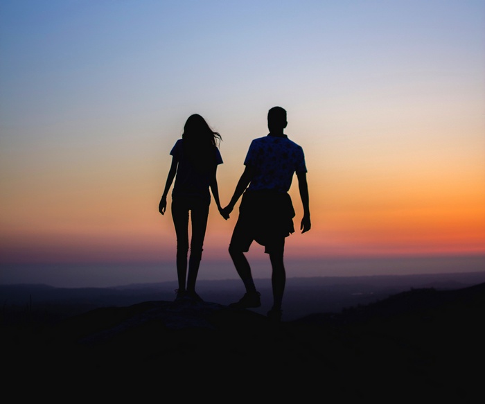 Couple holding hands at sunset