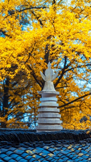 Pagoda on a tiled roof with autumn trees