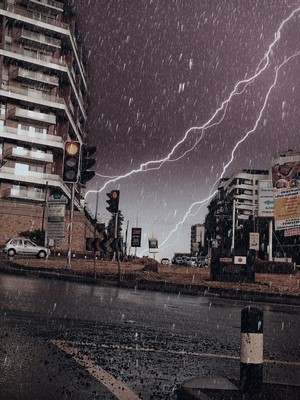 Lightning strikes during a rainstorm over a city street