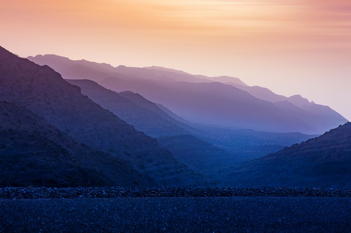 Mountain range at sunrise with purple and orange sky