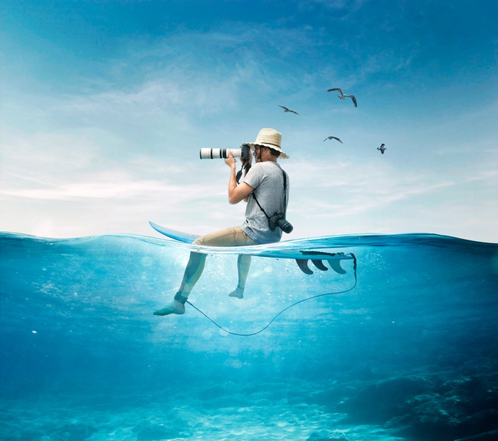 Photographer on Surfboard in the Sea with Birds