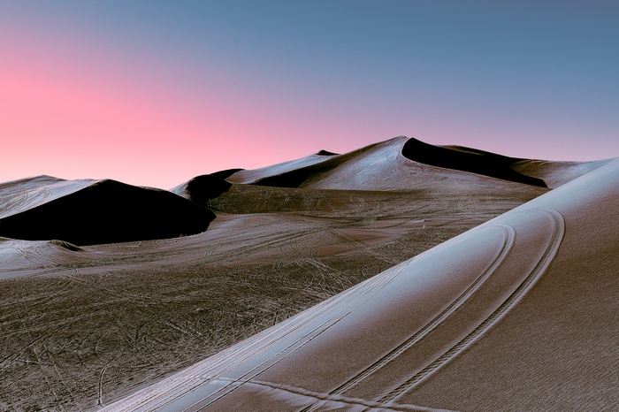 Desert dunes at sunset with pink and blue sky