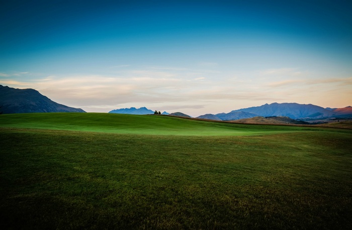 Rolling green hills and mountains under a blue sky