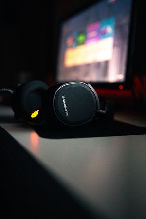 SteelSeries headphones in front of a computer screen