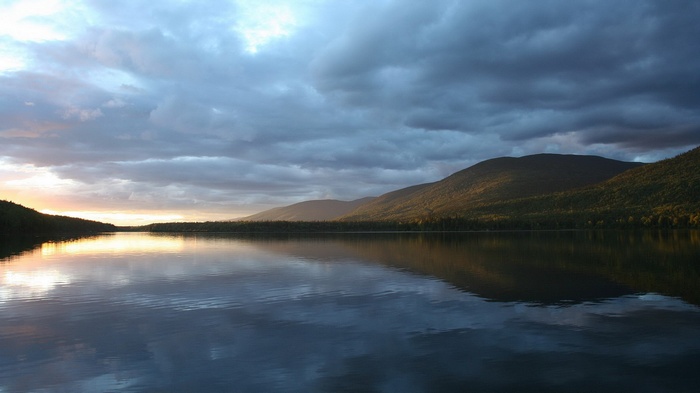 Lake and mountains at sunset with dramatic clouds
