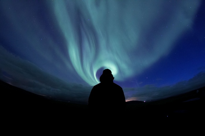 Silhouette of a man watching the Aurora Borealis