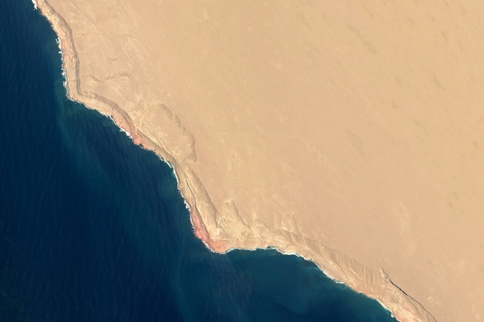 Satellite view of a desert coastline meeting the ocean