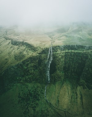 Waterfall in a green, misty landscape