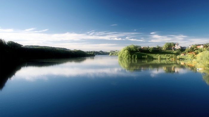 Lake with green hills and houses