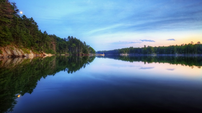 Moonlit lake with pine forest and reflection