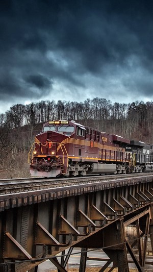 Maroon freight train crossing a bridge