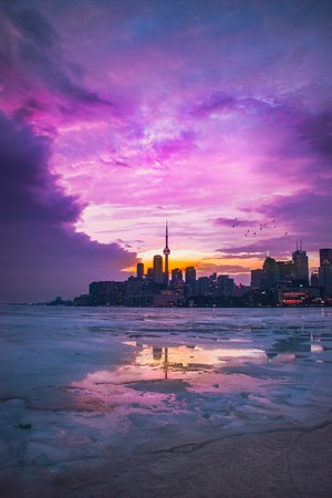 Toronto skyline at sunset over icy water