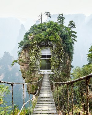 Suspension bridge leading to a house on a rocky island