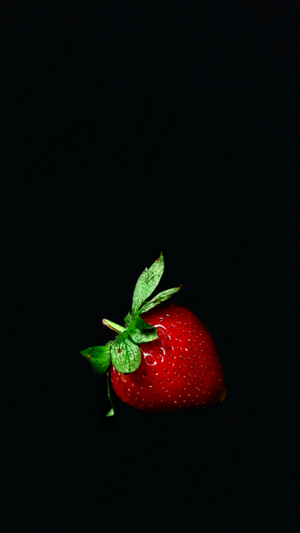 Single strawberry on a black background