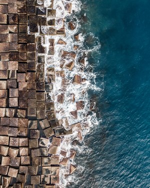 Aerial view of concrete blocks and waves on the coast