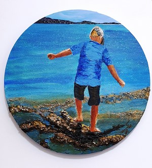 Boy walking on rocks by the sea