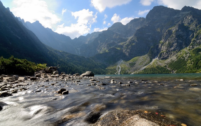 Mountain lake with rocky shore and flowing water