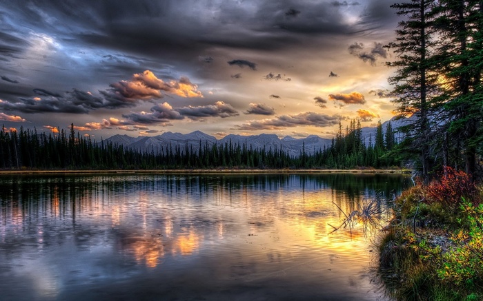 Lake and mountains at sunset with dramatic clouds