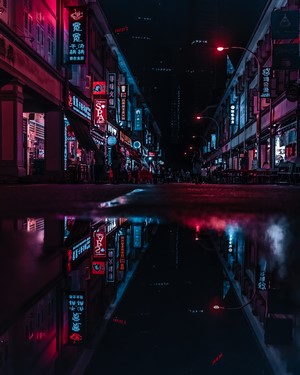 Neon lights reflecting on wet street at night in Asia