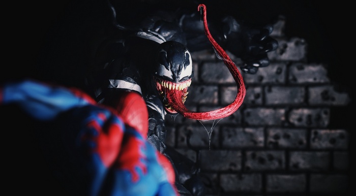 Venom and Spider-Man action figures in front of a brick wall