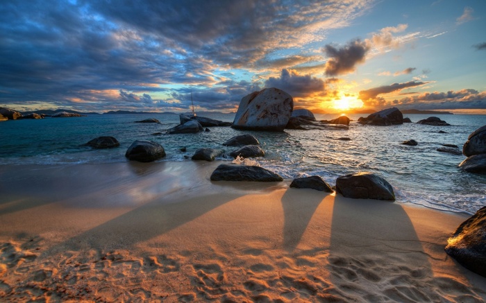 Sunset over a rocky beach with crashing waves