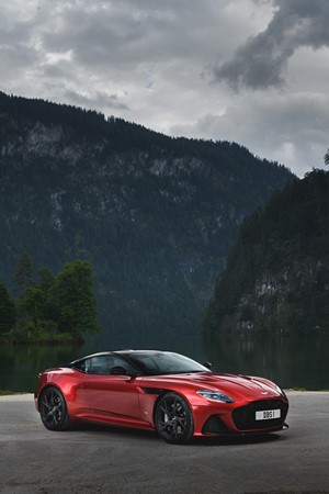 Red Aston Martin DBS Superleggera parked by a lake