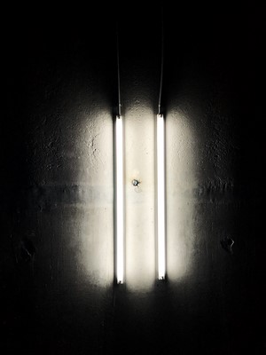 Two vertical fluorescent lights on a dark wall