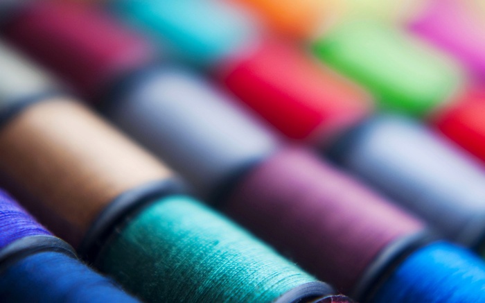 Macro view of colorful sewing threads on spools