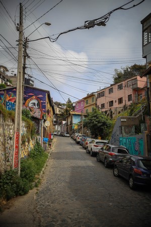 Street with parked cars and graffiti in a city