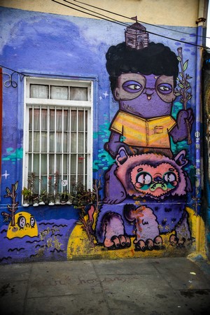 Graffiti of a purple character and a creature on a wall
