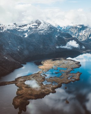 Aerial view of a lake with a snow-capped mountain range