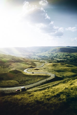 Winding road through rolling green hills in England