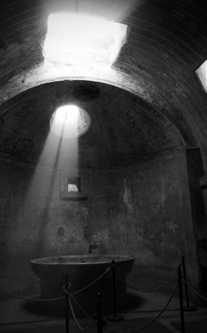 Ancient bath with sunlight streaming through openings