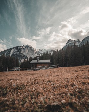 Wooden cabin in a mountain landscape with pine trees
