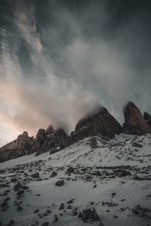 Snowy mountains under cloudy sky