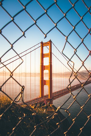Golden Gate Bridge through a chain-link fence