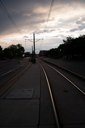 Street with tram tracks and overhead wires at dusk