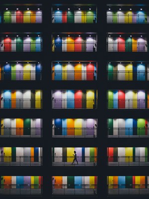 Colorful doors and balconies at night with a person walking